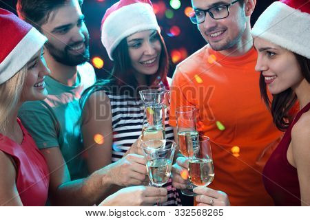 Happy group of young friends touching the glases with each other