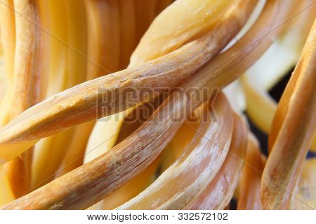 Salted braided soft russian cheese, a great snack for beer. Gossip in the form of a pigtail. Close-up.