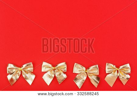 Golden Holiday Bows On A Red Background. Holidays Mock-up With Copy Space For Your Design. Flat Layo