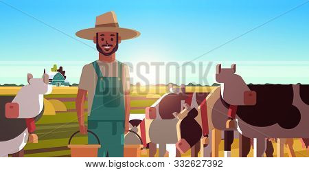 Milkman Holding Buckets With Fresh Milk Farmer Standing Near Herd Of Cows Grazing On Grassy Field Ec