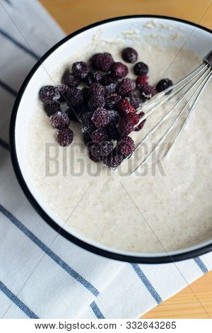 Black Raspberry In White Metal Bowl With Batter And Whisk On Wooden Table, Cooking Homemade Oladyi O