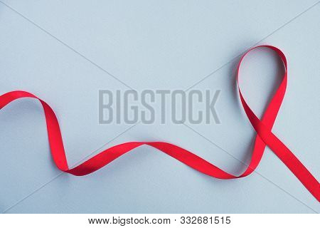 Red Ribbon Awareness Aids On A Light Blue Background. Medicine Concept, World Aids Day Campaign. Top