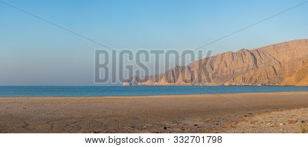 Panorama Of Ge Town Of Bukha Beach View To The Musandam Mountains In Oman At Sunset.