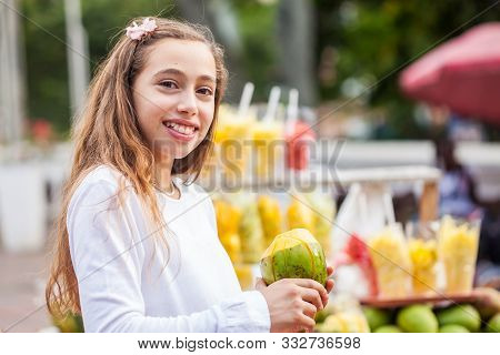 Beautiful Young Girl At Paseo Bolivar Square In The City Of Cali Eating Tropical Fruits In Colombia