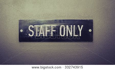 Staff Only - Inscription In White Letters On Black Frame On Grey Door, Toned