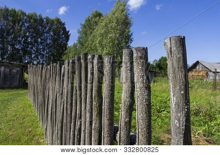 Plain Mossy Wooden Fence In The Typical Old Russian Style On A Clear Summer Day