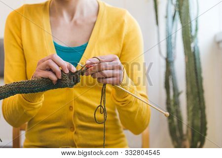 Female Hands Close-up. Young Woman Is Knitting. Knitting Needles And Threads. Multi-colored Yarn. Ha