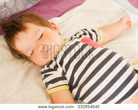 Sleeping Baby On Parents Bed. 0-1 Year Old Baby. Portrait Of A Newborn In The Parents Bed. Babys Day