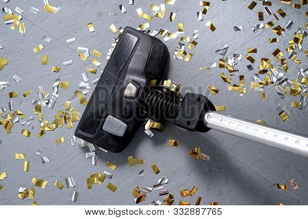 Vacuum Cleaner Cleans Up Bright Confetti. The Party Is Over. House Cleaning. Close-up. Top View.