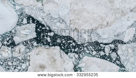 Icebergs drone aerial photo top view - Climate Change and Global Warming - Icebergs from melting glacier in icefjord in Ilulissat, Greenland. Arctic nature ice landscape in Unesco World Heritage Site.