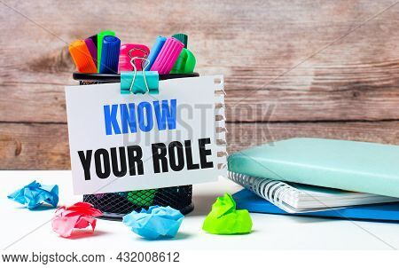 On The Desktop And Against The Background Of A Wooden Wall, There Is A Stand With Multi-colored Felt