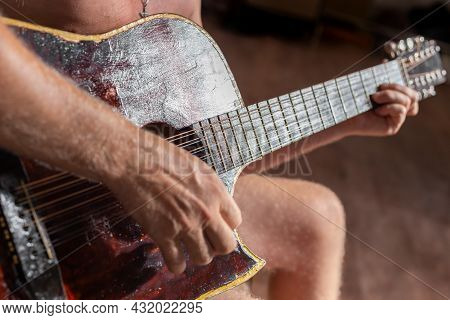 A Man Plays A Twelve-string Acoustic Guitar. Hobbies And Entertainment.