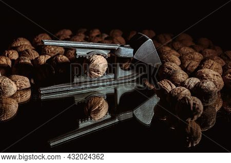 Walnut In A Nutcracker Close-up. Dark Background. Beautiful Background With Food. Healthy Ingredient