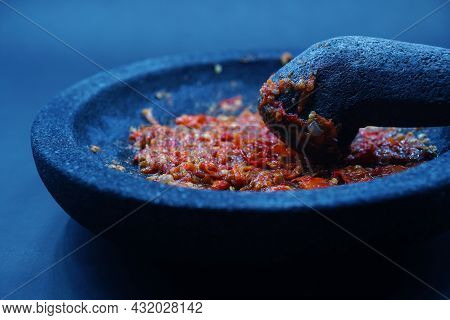 Red Chili Sauce On A Stone Mortar And Pestle. Dark Background, Focus Selected.