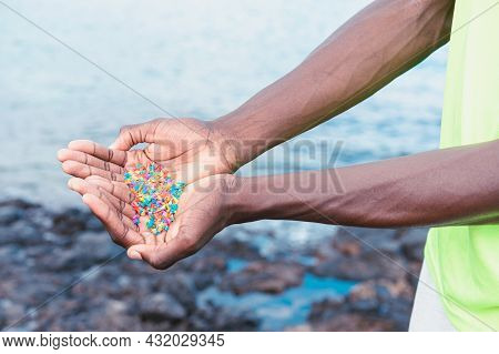 Hands Full Of Microplastics On The Beach. Different Plastic Colored ... Plastic Pollution Concept.