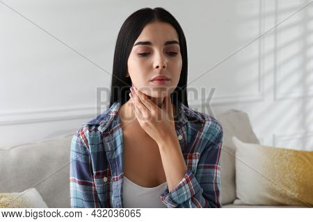 Young Woman Doing Thyroid Self Examination At Home