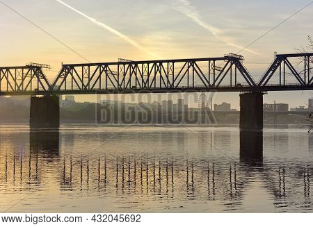 Early Morning On The Great Siberian River, Golden Dawn With Clouds, A City On The Bank In The Distan
