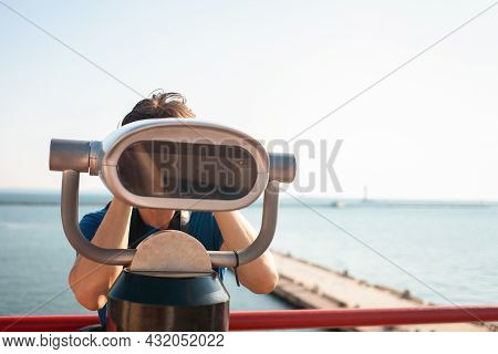 Man Looks Through Stationary Binoculars. Binoscope On Observation Deck Near Sea. Seaport In Odessa. 