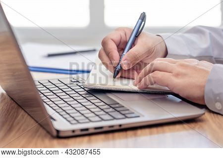 Business Man Write On Notebook Paper And Use Laptop Computer Working And Analyzing With Document Dat