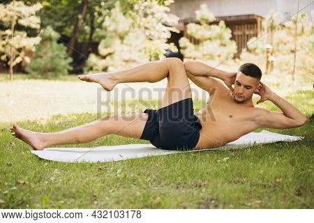 Full-length Portrait Of Young Handsome Mandoing Sport Outdoors On Warm Summer Day
