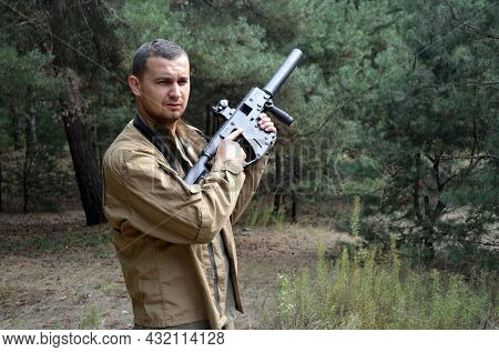 Man with KRISS Vector 9*21 caliber submachine gun in the forest. Unformal shooting range near Kiev. September 6,2021. Kiev Region, Ukraine