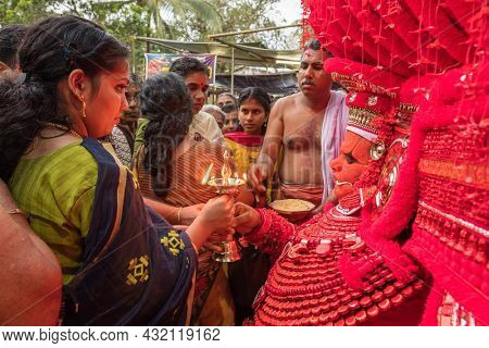 Kannur, India - December 2, 2019: Theyyam perform during temple festival in Kannur, Kerala, India. Theyyam is a popular ritual form of worship in Kerala, India