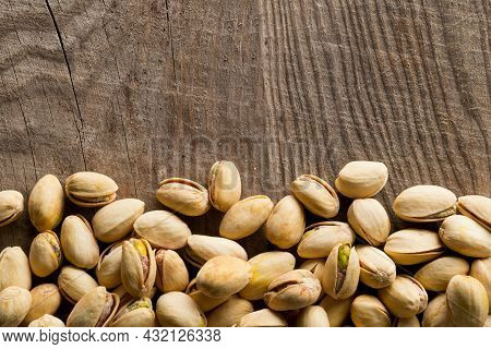 Border Of Salted, Roasted Green Pistachio Nuts Snack On Wood Background, Healthy Food Snack, Copy Sp