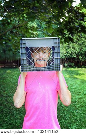 Teen boy holding a milk crate over his head ready for the social media milk crate challenge