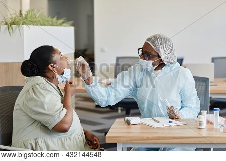 Female Doctor In Protective Suit Taking Nasal Swab To Collect Samples For Laboratory Coronavirus Tes