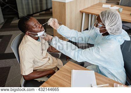 Doctor In Ppe Suit Collecting Nose Mucus With Swab To Test For Covid-19 Infection