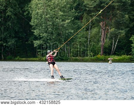 Straz, Czechia. 29th Of July, 2021. Wake Boarding  Boy On Lake, The Forest In Blurry Background.