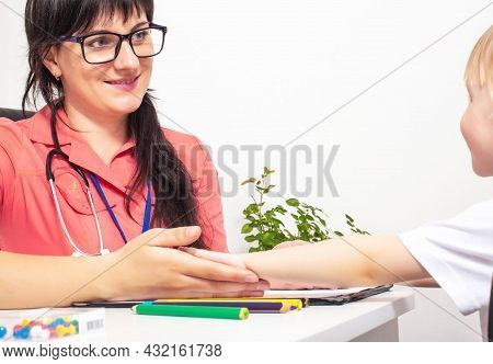 A Young Beautiful Woman, A Children's Doctor, Holds Out His Hand To A Little Girl 3-4 Years Old. The