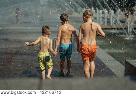 Three Caucasian Boys Going To Run Throgh Splashing Fountain On Hot Summer Day In City Of Saint-peter