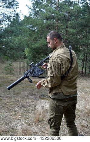 Man with KRISS Vector 9*21 caliber submachine gun in the forest. Unformal shooting range near Kiev. September 6,2021. Kiev Region, Ukraine