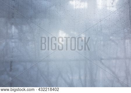 Water Drops On The Fogged Glass In The House Against The Background Of Winter