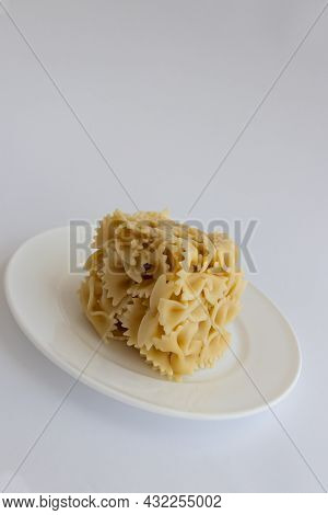 Cooked Farfallini Pasta In A Shape Of Cube On A White Plate.