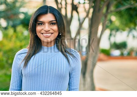 Beautiful hispanic woman smiling confient at the park
