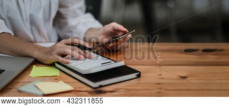 Close Up Hand Of Accounant Or Bookkeeper Using Calculator And Mobile Phone, Calculating Financial Ex