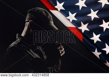 National American Holidays. The Silhouette Of A Male Praying Soldier On A Black Background With An A