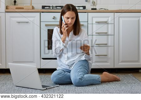 Portrait Of Young Adult Female Wearing White Shirt And Jeans, Looks Serious And Concentrated, Talkin