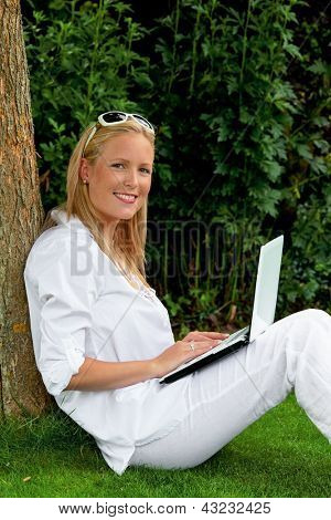 nuori nainen istuu kannettavan tietokoneen Internet ja surffaa internetissä. Pysäköinti, Park