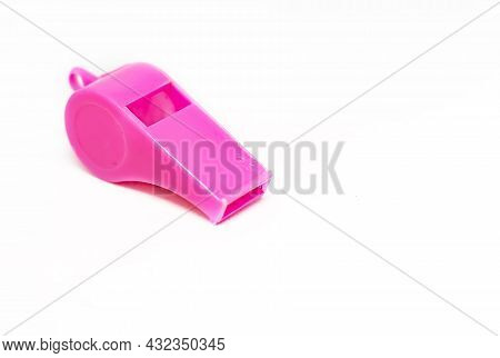 A Pink Plastic Whistle Isolated On A White Background. Tool For Sport And Training. Warning And Shri