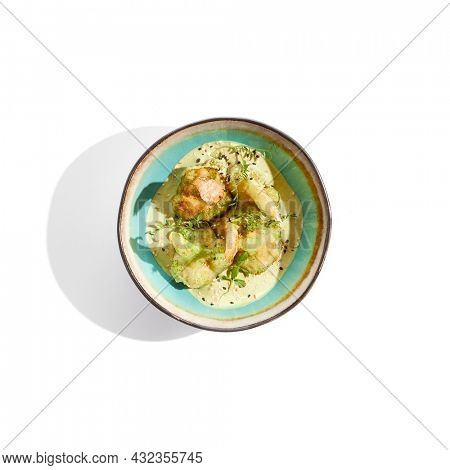 Fried tempura broccoli with peanut sauce in bowl. Vegeterian hot dish - florets cabbages roasted  in klar on white background. Veggie menu for asian restaurant. Hot vegan appetizers plant based