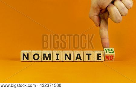 Nominate Symbol. Businessman Turns A Wooden Cube And Change Words 'nominate No' To 'nominate Yes'. B
