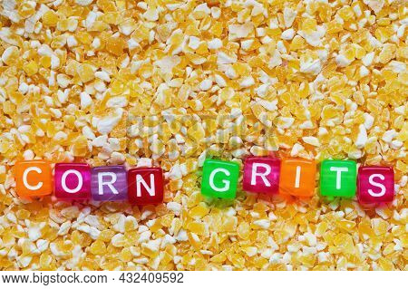 Background From Corn Grits With The Inscription Of Corn Grits In Colored Letters On Cubes. Closeup, 