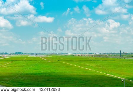 Landscape Of The Airport Runway And Green Grass Field With Blue Sky And White Clouds. Plane On Taxiw