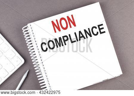 Non Compliance Text On Notebook With Calculator And Pen