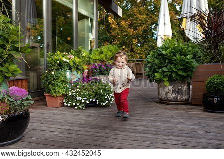 Little Smiling Boy Runs On A Terassa Of Cafe.  Lovely Kid Smiles And Has Joy. Outdoor Activities For