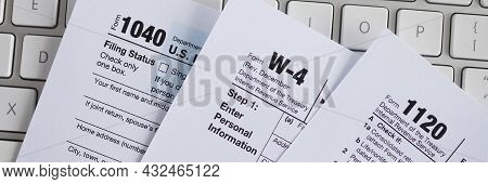 Tax Form Documents Lying On Computer Keyboard Closeup