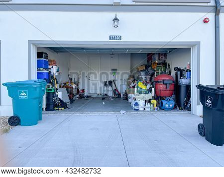 An Unorganized Garage Filled With A Lot Of Stuff In A Neighborhood.